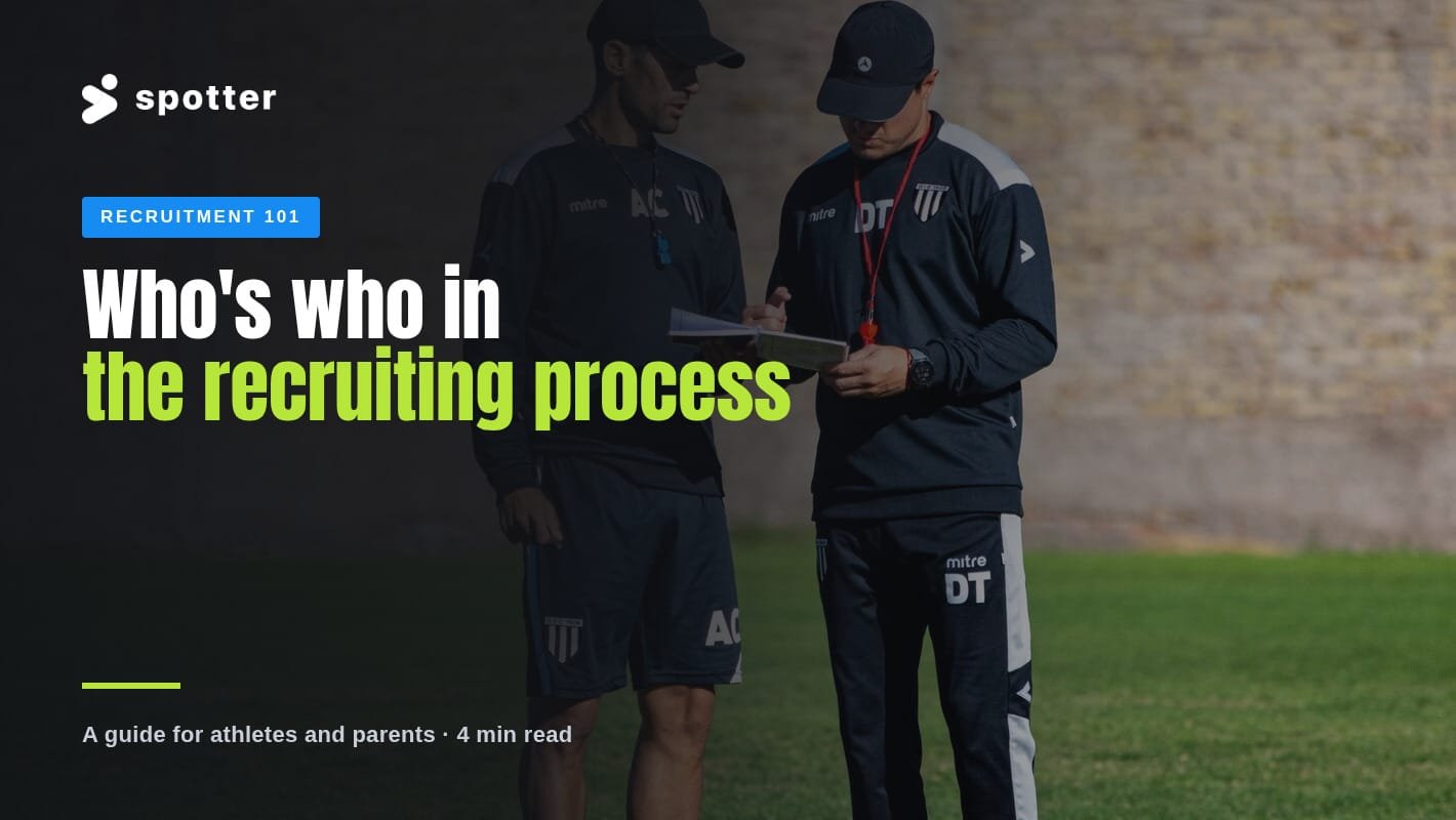 Two soccer coaches reviewing notes on a clipboard on the training pitch